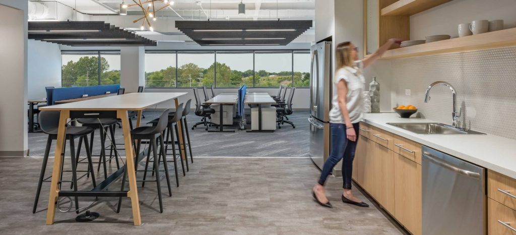 woman reaching for glass in office kitchen